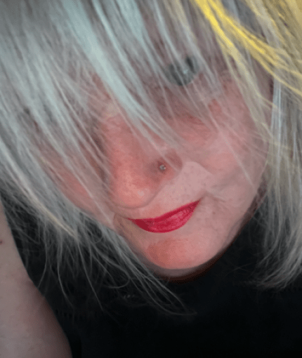 A picture of Alison staring upwards through her fringe