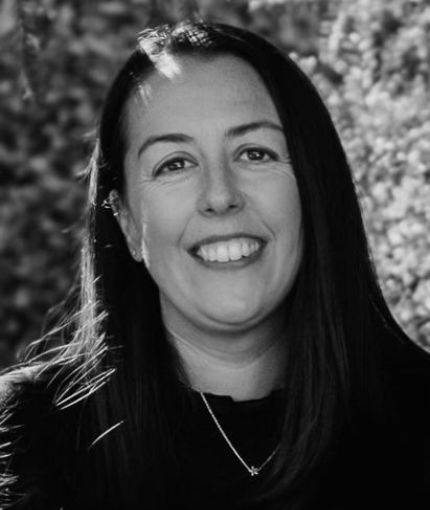 Black and White photo of Hayley smiling wearing a black top
