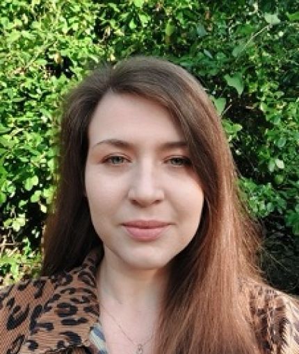 Photograph shows a white woman in her mid-30s with long brown hair.