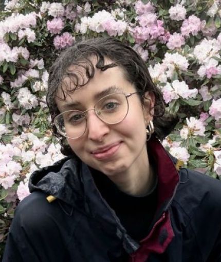 Person smiling in front of flowers