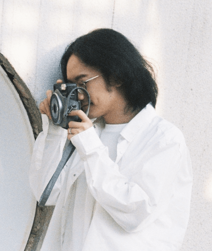 A young man photographing his wife on their wedding day.