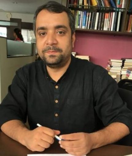 A person wearing black shirt sitting around books