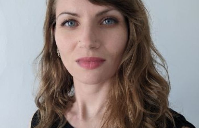 Brunette female wearing black top, facing forward