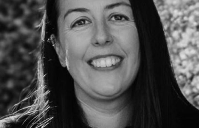 Black and White photo of Hayley smiling wearing a black top