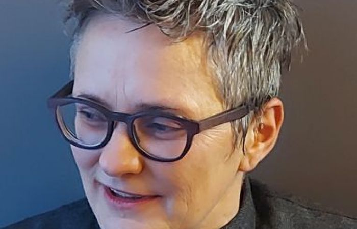 head and shoulders photo of Niamh Moore, white woman, with short greying hair, wearing glasses