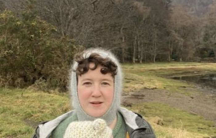  Portrait of a person outdoors by a lakeside woodland landscape, carrying a baby in a front carrier